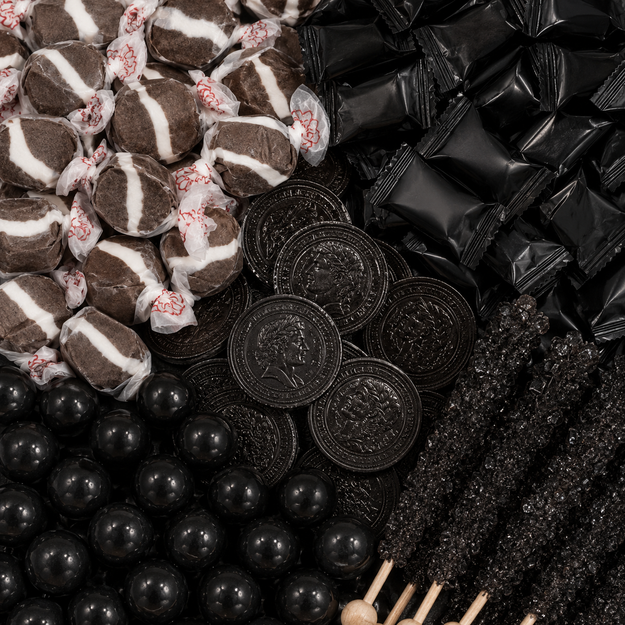 Black candy assortment featuring striped taffy, black wrapped candies, chocolate coins, gumballs, and rock candy sticks.