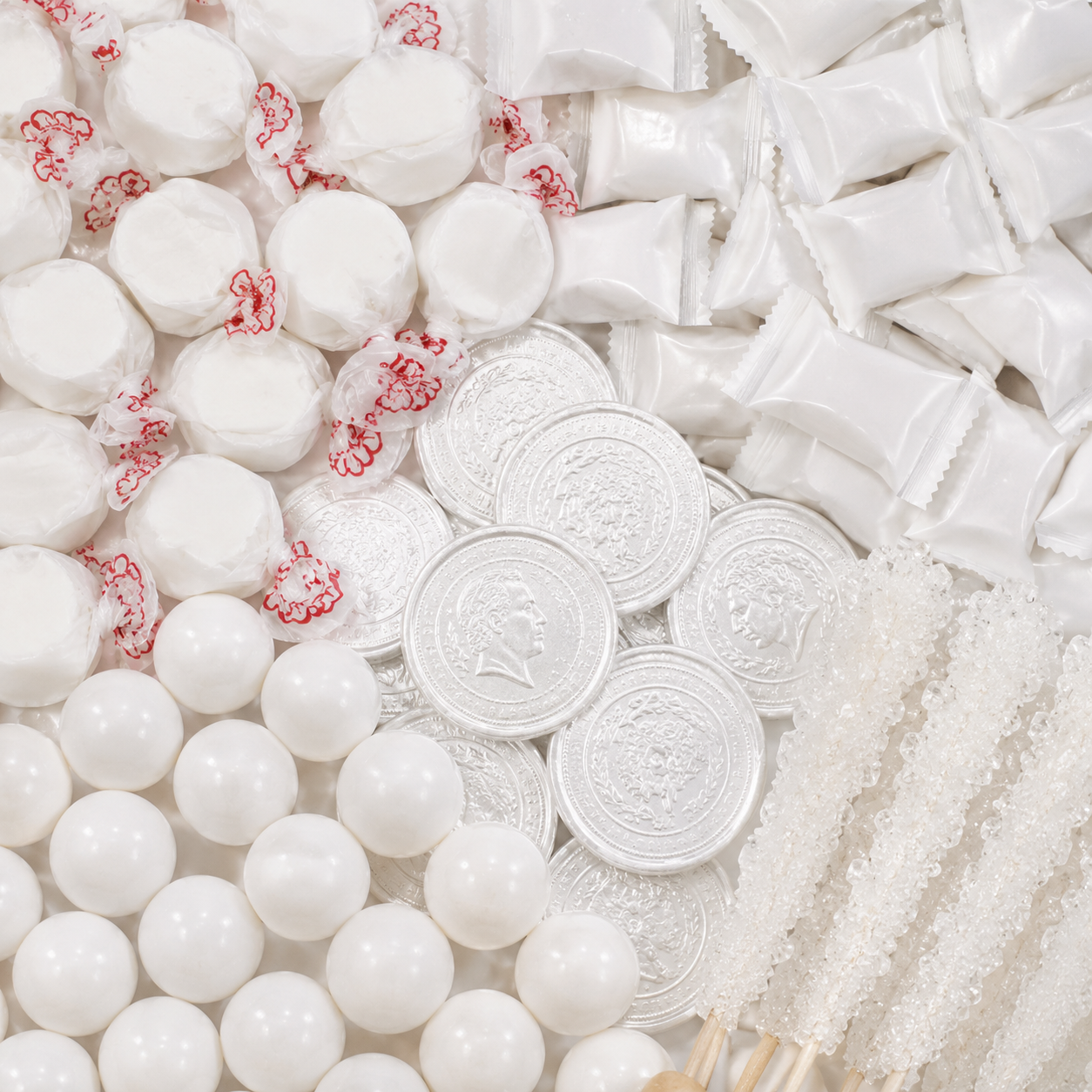 White candy assortment featuring taffy, white wrapped candies, chocolate coins, gumballs, and rock candy sticks.