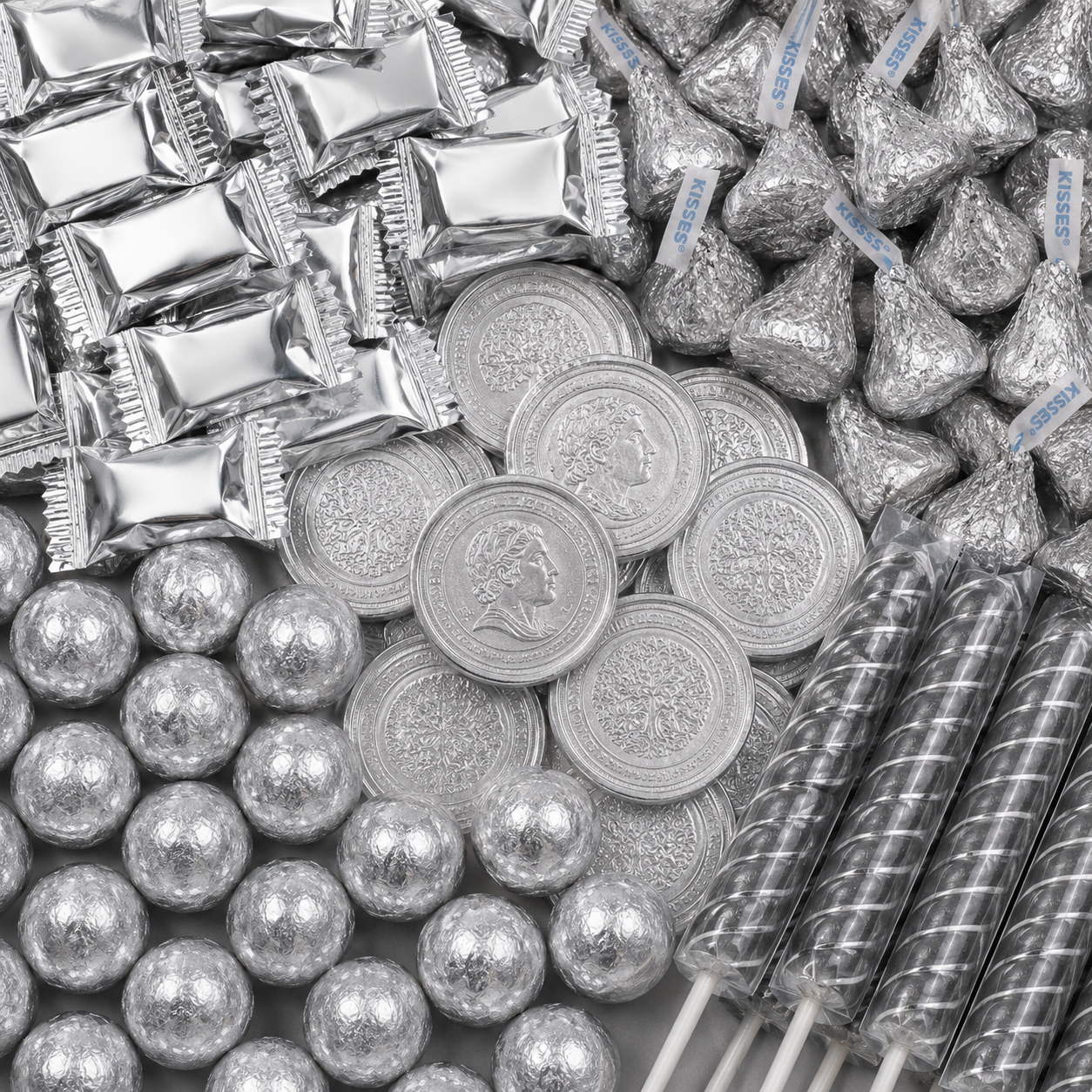 Silver candy assortment featuring silver wrapped candies, Hershey’s Kisses, chocolate coins, foil-wrapped chocolate balls, and black swirl candy sticks.
