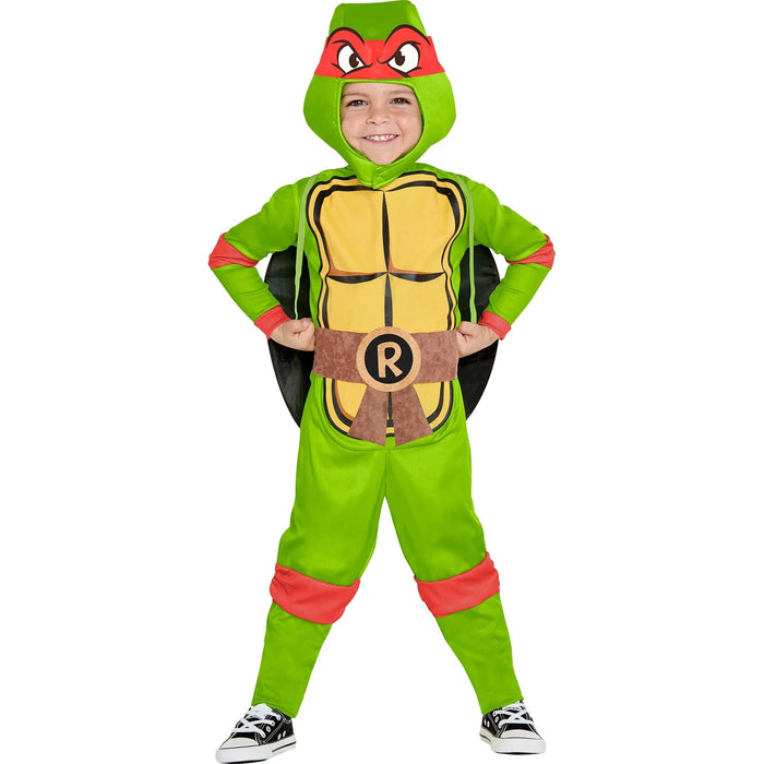 Child wearing a green Teenage Mutant Ninja Turtles Raphael costume with a yellow shell, red mask, brown belt with R logo, red arm and leg accents, and black cape.