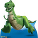 Green dinosaur character with wide grinning teeth, tan belly scales, and a blue fin tail, posed against a blue background on a cardboard standup.
