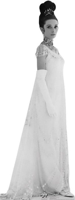 Black and white cardboard standup figure of a woman wearing an elaborate white beaded gown with short sleeves, long gloves, a tiara, and pearl necklaces, styled in classic 1960s fashion.