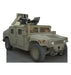 Tan military Humvee with mounted weapons on roof and armed soldier figure, cardboard standup cutout against white background.