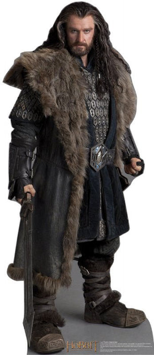 Life-size cardboard standup of a bearded man with long dark hair wearing a fur-lined brown cloak over black chainmail armor, holding a sword, with "The Hobbit" text at the base.