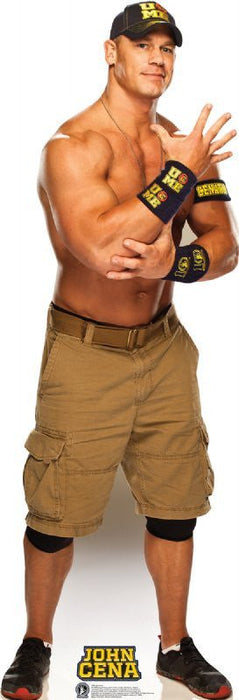 Life-size cardboard standup figure of a muscular man wearing a tan cargo shorts, black wristbands with gold text, black cap with gold logo, and black shoes in a flexing pose.