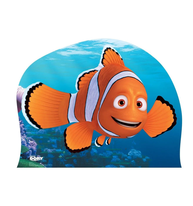 Bright orange clownfish character with white and blue striping smiles against an underwater coral reef background on a curved cardboard standup.