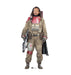 Cardboard standup figure of a character in tan military-style jumpsuit with red armor plating, ammunition belt, and black cape, holding a rifle across chest.
