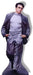 Man in gray cardigan and light blue shirt with hands in pockets stands against white background in a classic posed stance.