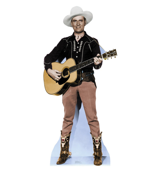 Life-size cardboard standup of a cowboy wearing a white Stetson hat, black embroidered western jacket, tan pants, and ornate brown cowboy boots, holding an acoustic guitar.