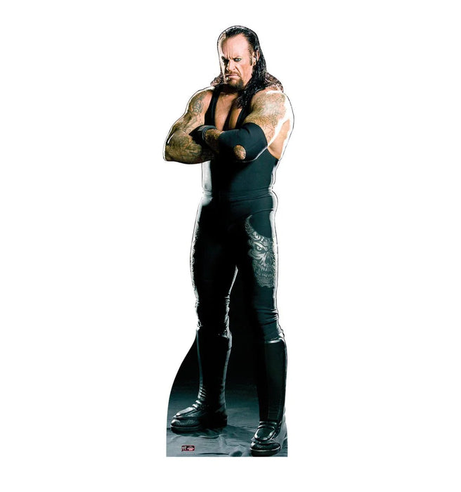 Life-size cardboard standup figure of a wrestler with long black hair, facial hair, and extensive arm tattoos, wearing a black sleeveless wrestling outfit and black boots.
