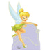 Cardboard cutout of Tinker Bell, a fairy character with blonde hair in a bun, blue wings, and a green dress, posed against a purple background with gold sparkles.