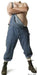 Shirtless man with crossed arms wearing loose blue jeans and green lace-up boots in a wide-legged stance.