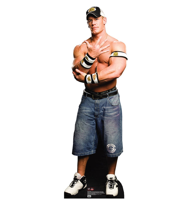 Life-size cardboard standup figure of a muscular man wearing a black and gold cap, white and gold wristbands, blue denim shorts, and white sneakers, posed with arms crossed.