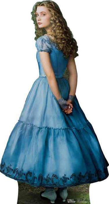 Young woman with long curly blonde hair wearing a blue puffy ball gown dress with puffed sleeves and decorative embroidery at the hem, standing against a white background.