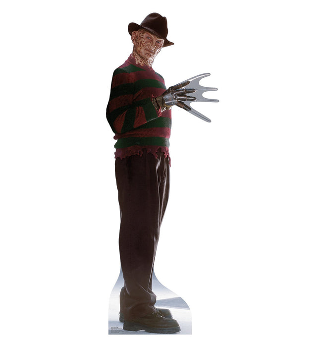 Life-size cardboard standup figure of a character wearing a brown fedora hat, red and green striped sweater, and dark pants, with a menacing metal gloved hand extended outward.