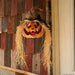 Full-length product photo of the 11 3/4" x 27 1/2" Hanging Pumpkin Head Plastic, shown against a plain white background — designed to hang. It measures about 11 3/4" x 5 3/4" x 27 1/2". A Halloween decoration.