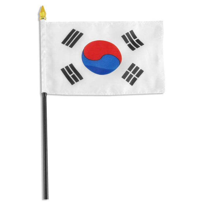 Small South Korean flag on a black stick featuring a white background with a red and blue yin-yang symbol in the center and four black trigrams in the corners.
