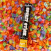 Black confetti cannon with white text reading "SPIRIT STICK" and "CONFETTI CANNON" displayed on a colorful bed of multicolored paper confetti pieces.