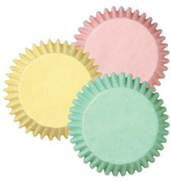 Three overlapping fluted baking cups in pastel yellow, pink, and mint green with ruffled edges displayed against a white background.