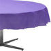 Purple plastic round tablecloth with ruffled edge draped over a dark metal table base on white background.
