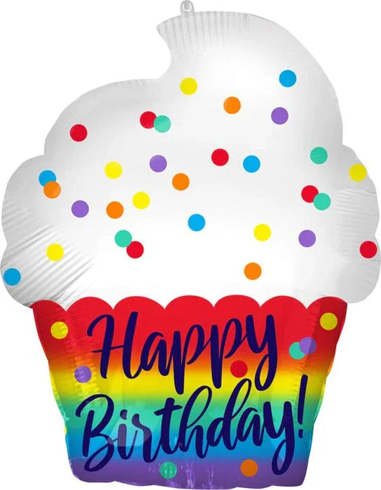 White cupcake-shaped mylar balloon with colorful sprinkles on top and rainbow-striped wrapper with "Happy Birthday" text in blue lettering.