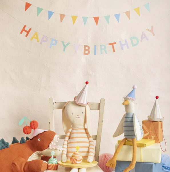 Children's birthday party scene with stuffed animals and 'Happy Birthday' banner.