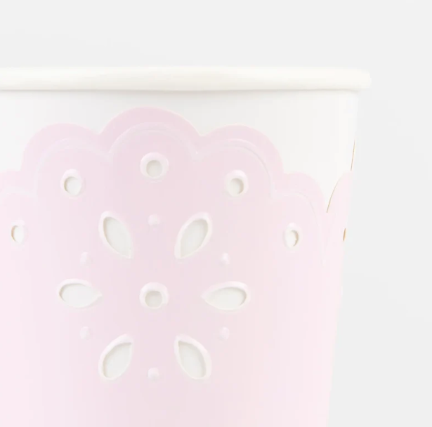 Close up  of a Broderie Anglaise pink and peach paper cup with delicate floral cutout details.