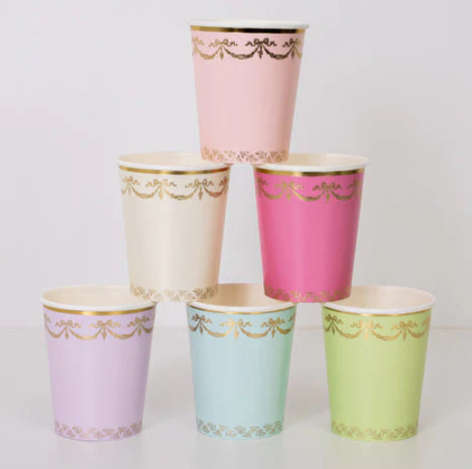 Ladurée Paris Cups in assorted pastel colors with metallic gold garland, bow, and trim details.
