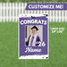 Purple and white yard sign featuring a photo of a graduate in cap and gown with "CONGRATS '26 Name" text, measuring 24 inches by 36 inches.