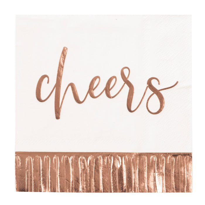 White beverage napkin with rose gold “cheers” script and metallic fringe-style foil border.