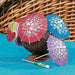 Colorful decorative parasol picks with white hibiscus flower prints in red, blue, and purple displayed on a woven basket with a turquoise background.