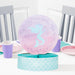 Mermaid Shine honeycomb centerpiece with pastel mermaid silhouette, pink and lavender round topper, and teal mermaid-scale base displayed on a party table.