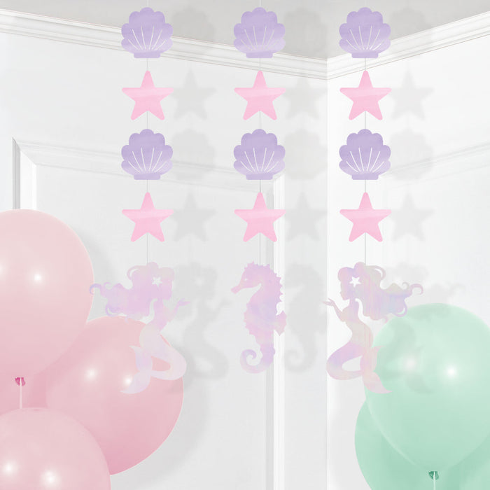 Mermaid Shine hanging cutouts with pastel shells, pink stars, mermaids, and seahorses displayed above pink and mint balloons.