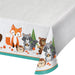Wild One plastic tablecover with woodland animals, trees, mushrooms, woodgrain details, and teal border on a white party table.