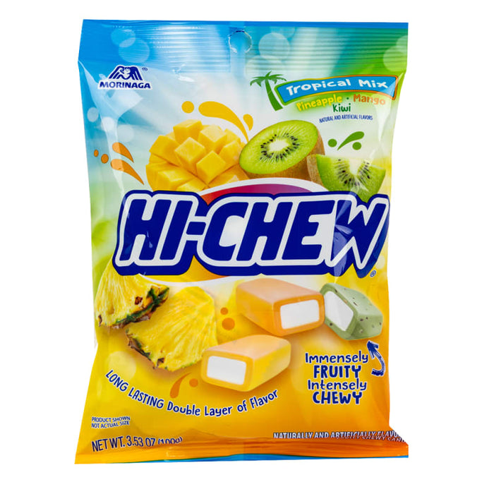 Hi-Chew Tropical Mix: soft chewy fruit candy cubes, bright tropical in color. Sold in a 3.53 oz clear plastic peg bag that hangs from a printed header card, with the candy visible inside.