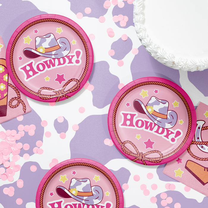 Pink 'Howdy!' buttons with cowgirl hats on a purple and pink patterned background