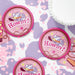 Pink 'Howdy!' buttons with cowgirl hats on a purple and pink patterned background