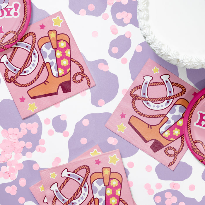Pink napkins with cowgirl boot and horseshoe designs on a patterned background