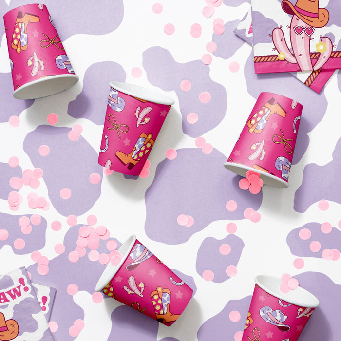 Pink party cups with cartoon western designs on a purple and white patterned background