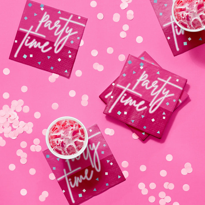 Turning Pink beverage napkins in hot pink with “party time” lettering and confetti design, styled on a pink party table with drinks and coordinating pink décor, 16-count pack.
