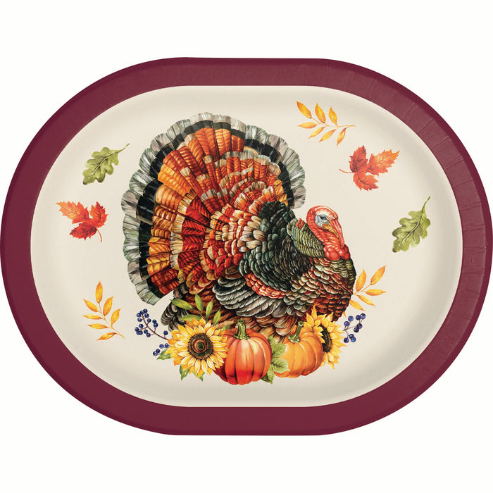 An oval paper plate featuring a colorful Thanksgiving turkey illustration with pumpkins, sunflowers, autumn leaves, and blue berries, surrounded by a dark burgundy rim on a white background.