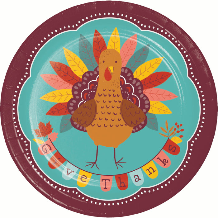 A round Thanksgiving-themed paper plate featuring a stylized brown turkey with multicolored autumn leaves on a turquoise background, surrounded by a dark burgundy border and the word 'Thanksgiving' in colorful letters.