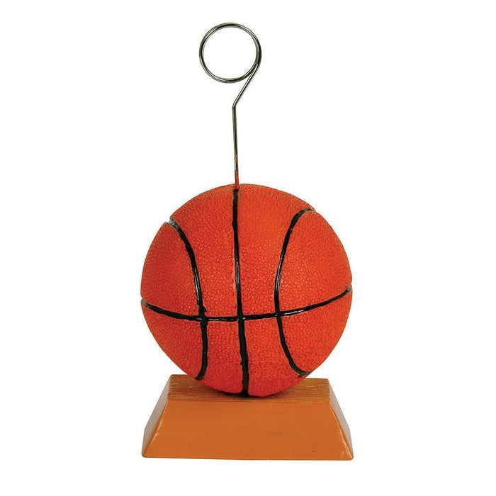 Red basketball with black panel lines sitting on an orange rectangular base with a curved metal wire holder extending upward.