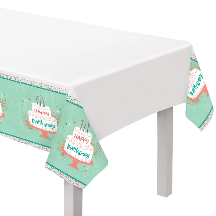 Happy Cake Day Plastic Table Cover with a white center and teal border featuring birthday cake illustrations, confetti accents, and Happy Birthday text.