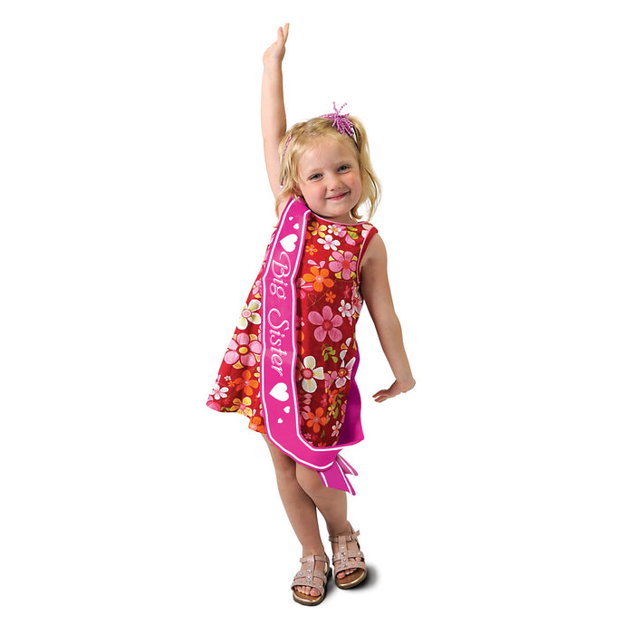 A satin sash worn across the body printed with a big sister design. Sold as a single piece.
