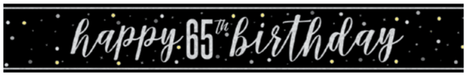 Black banner with white script text reading "happy 65th Birthday" surrounded by gold and white dots on a dark background.