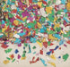 Colorful tissue confetti in red, purple, green, blue, yellow, and white pieces scattered across a white background in varying densities.