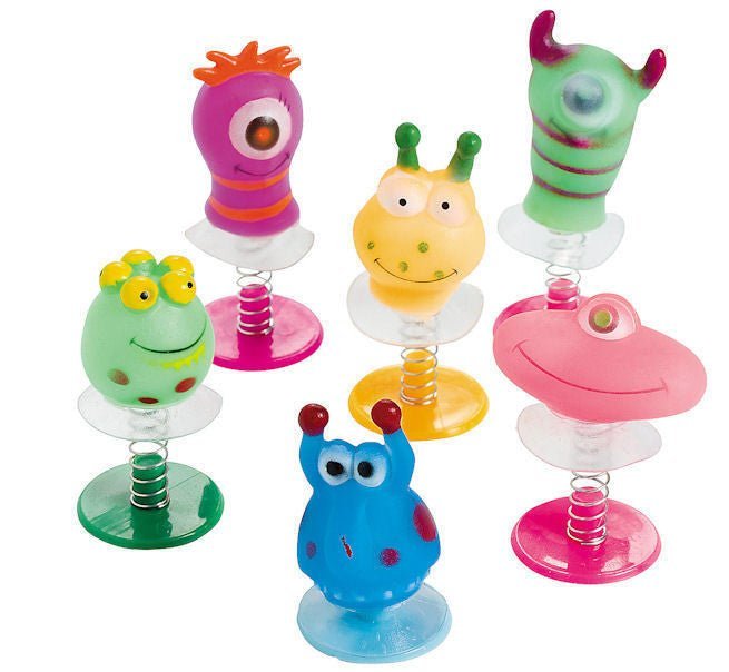 Six colorful spring-loaded monster toys with googly eyes in pink, green, yellow, blue, and lime green, each mounted on a clear base with a coiled spring.
