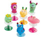 Six colorful spring-loaded monster toys with googly eyes in pink, green, yellow, blue, and lime green, each mounted on a clear base with a coiled spring.