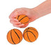 Hand holding one small orange foam basketball with black lines above two additional basketballs of the same size displayed on a white background.